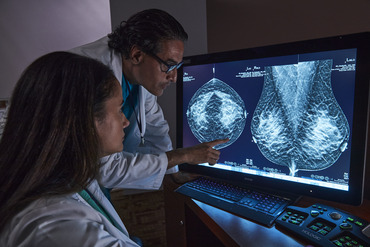 Radiographers reviewing tomosynthesis mammography on a screen