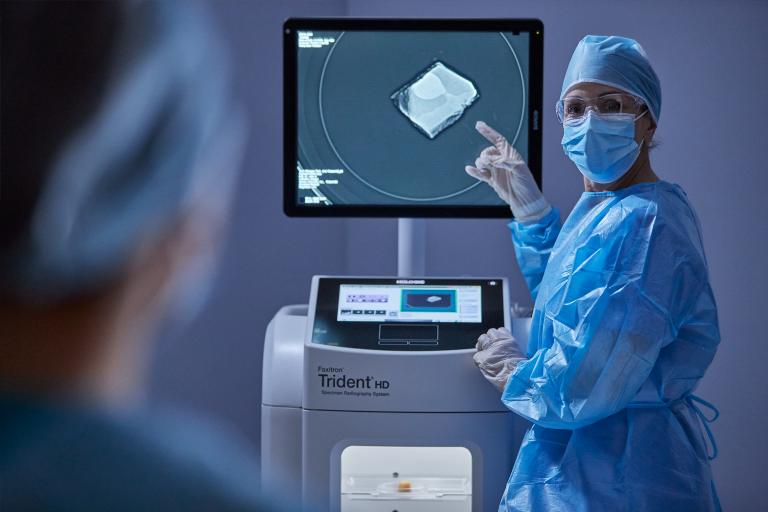 Healthcare professional pointing at monitor and talking to patient