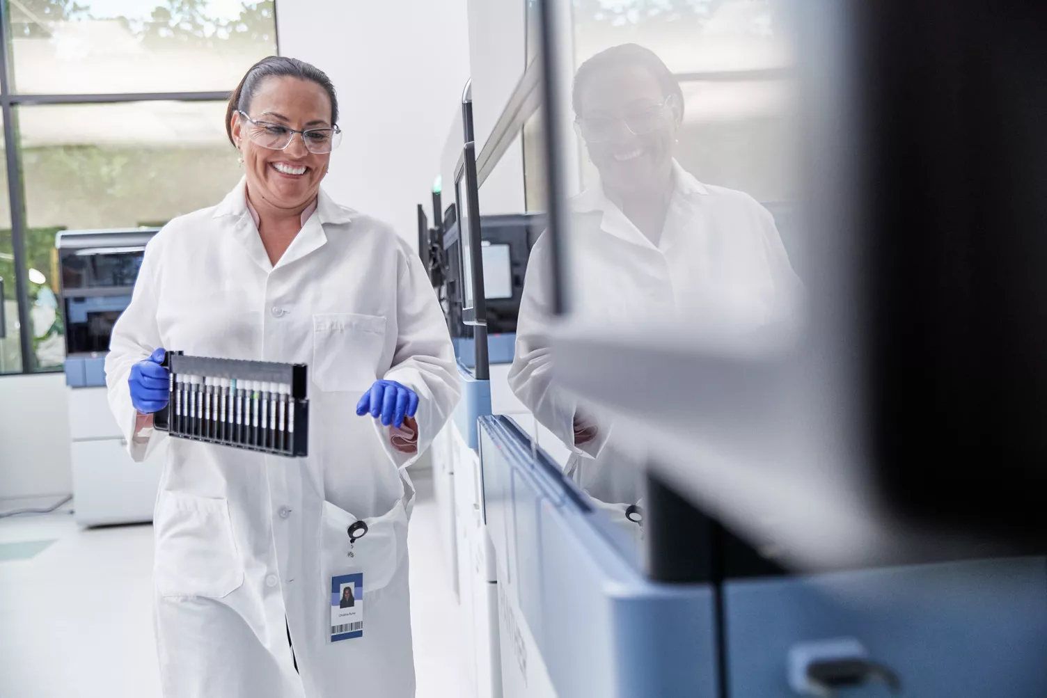 Female lab technician carrying test tubes in lab setting