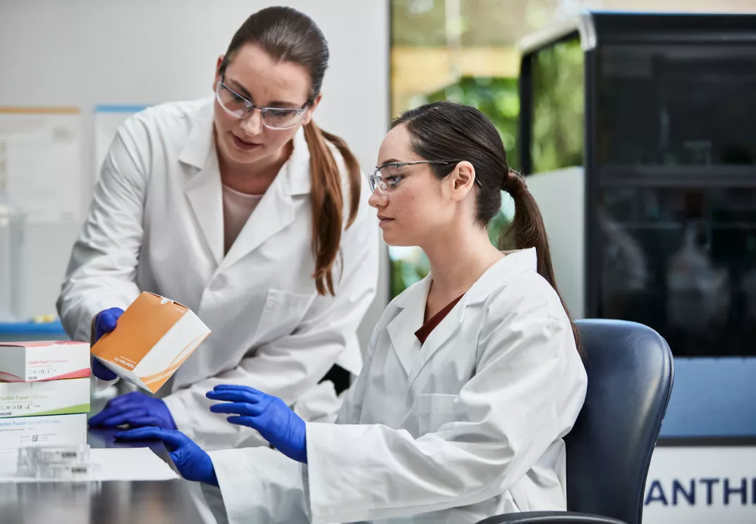 Female technicians reviewing assay boxes