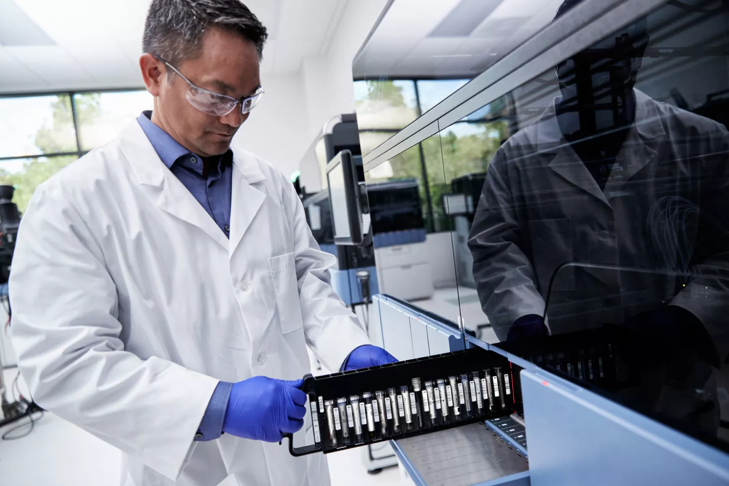 Lab technician putting test tubes into equipment